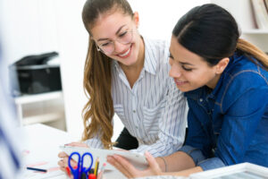 Zwei Studentinnen beim Besprechend einer Überarbeitung einer wissenschaftlichen Arbeit.